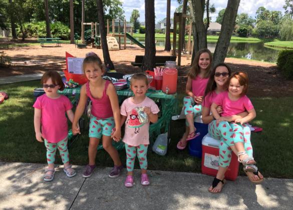 6 kids posing for picture at stand